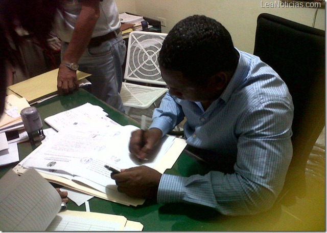 foto del alcalde firmando títulos de tierra