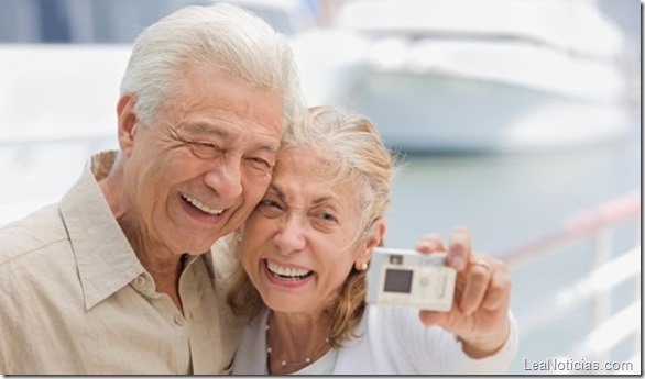 Senior Couple Using Digital Camera at Marina --- Image by © Royalty-Free/Corbis