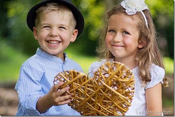 Two laughing kids holding wicker heart