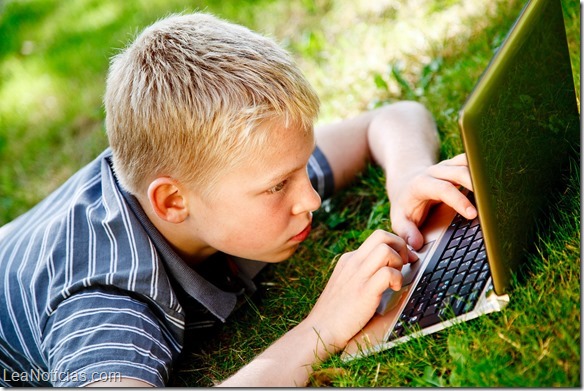 Boy playing with computer outside