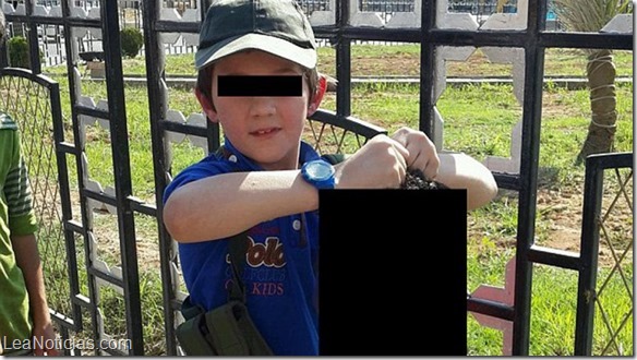hijo de yihadista australiano sosteniendo una cabeza