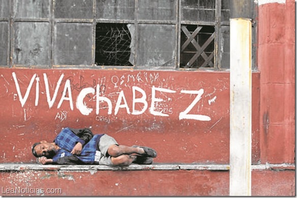 A man sleeps near graffiti in Havana January 16, 2014. The graffiti on the wall reads reads, "Long live Chavez" (L), referring to Venezuela's late former president Hugo Chavez, and "long live Fidel and Raul".  REUTERS/Enrique de la Osa (CUBA - Tags: POLITICS SOCIETY)