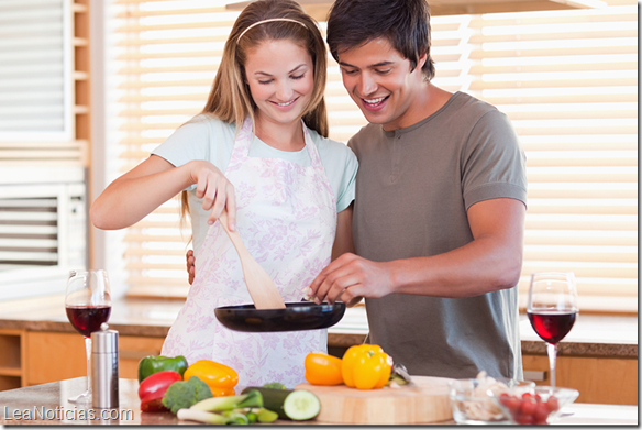 Couple cooking dinner while drinking red wine