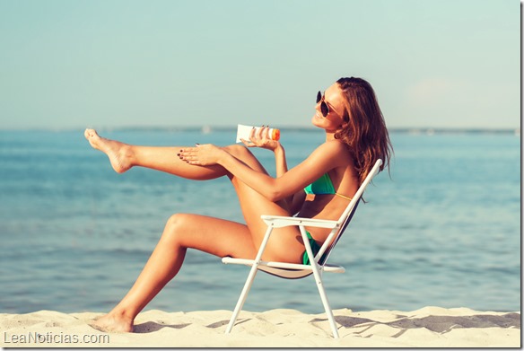 smiling young woman sunbathing in lounge on beach