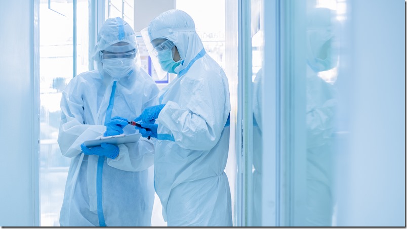 Asian woman doctor in personal protective suit with mask writing on quarantine patient chart, holding test tube with blood sample for screening coronavirus. Coronavirus, covid-19 concept.