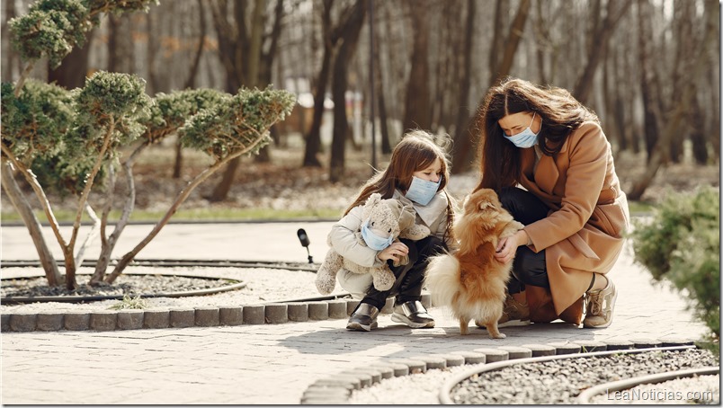 Mother with daughter walks outside in masks