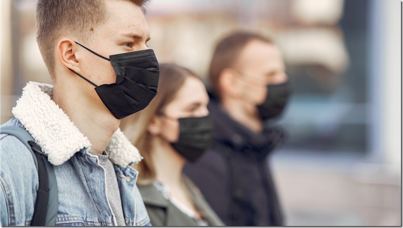 People in a masks stands on the street