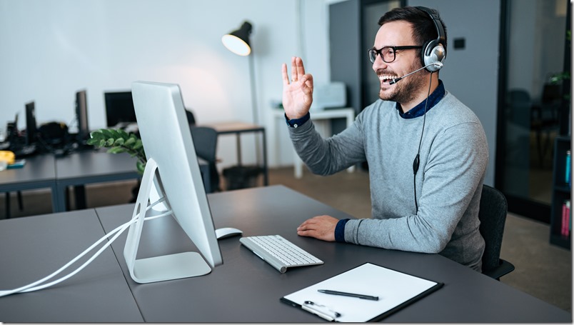 Handsome technical support agent talking to a client and giving him okay sign. Video call.