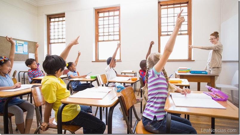 Pupils raising hand in classroom 
