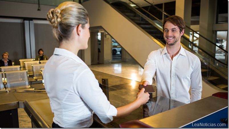 Female staff giving boarding pass at the check in desk