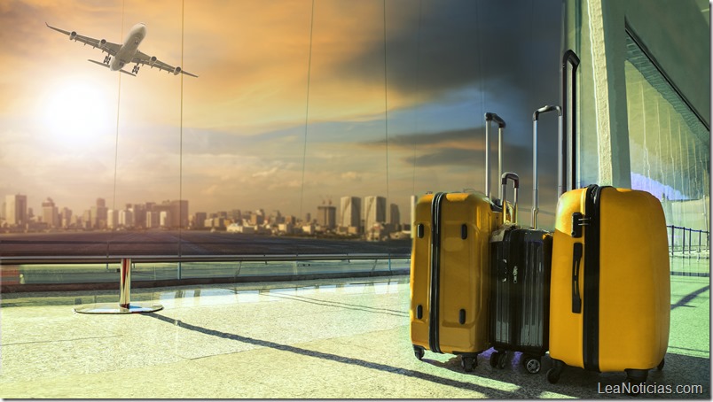 traveling luggage in airport terminal building with passenger plane flying over runway